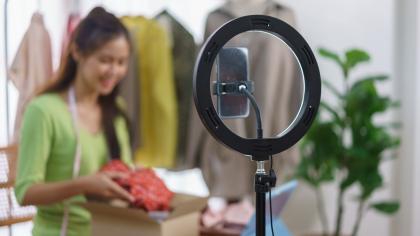 An online fashion business owner presents her products during a live streaming session.